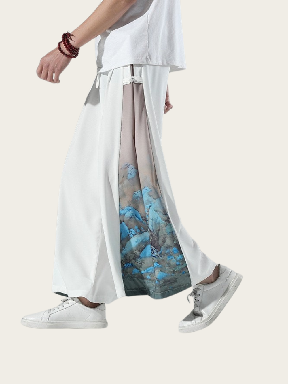 Person wearing a white top and wide-leg pants with a blue abstract pattern on a white background