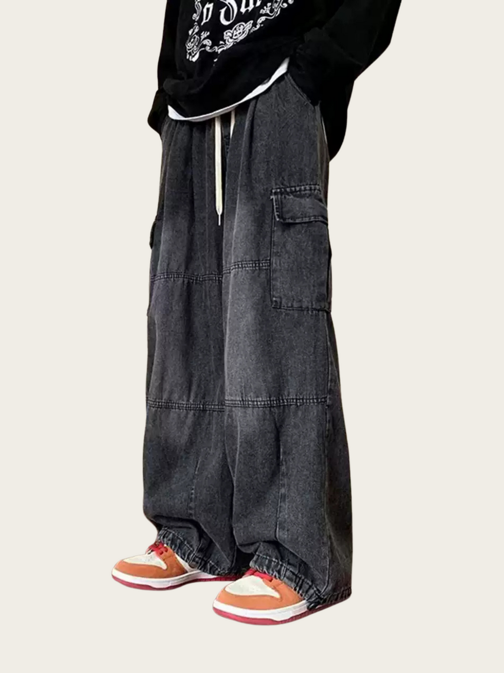 Person wearing black cargo pants with a white background