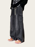 Person wearing black cargo pants with a white background