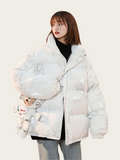 Person wearing a white puffer jacket with cartoon character design on a plain background