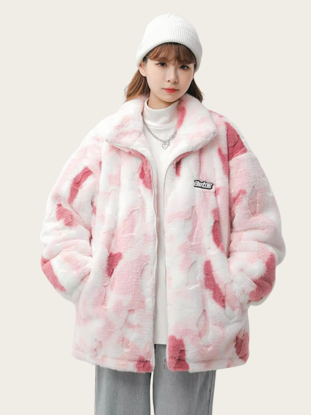 Person wearing a pink and white tie-dye jacket on a plain background