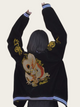Person wearing a black jacket with gold dragon design on the back against a plain background