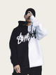 Person wearing a black and white hoodie with a brand logo on a plain background