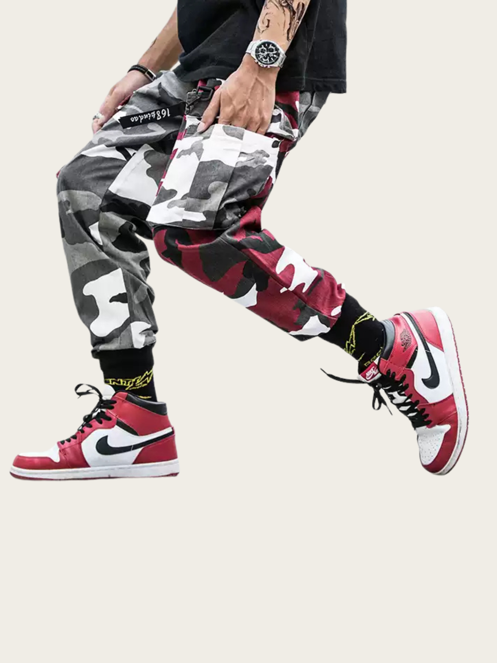 Person wearing camouflage pants, red sneakers with black swoosh logo, and a patterned bag.