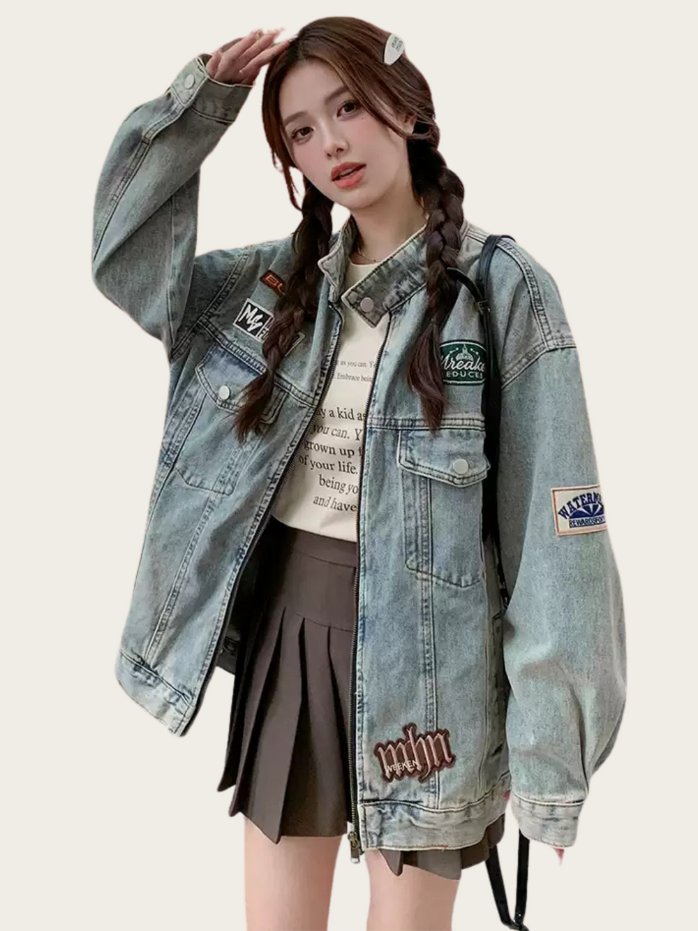 Person wearing a denim jacket with patches and a backpack on a plain background