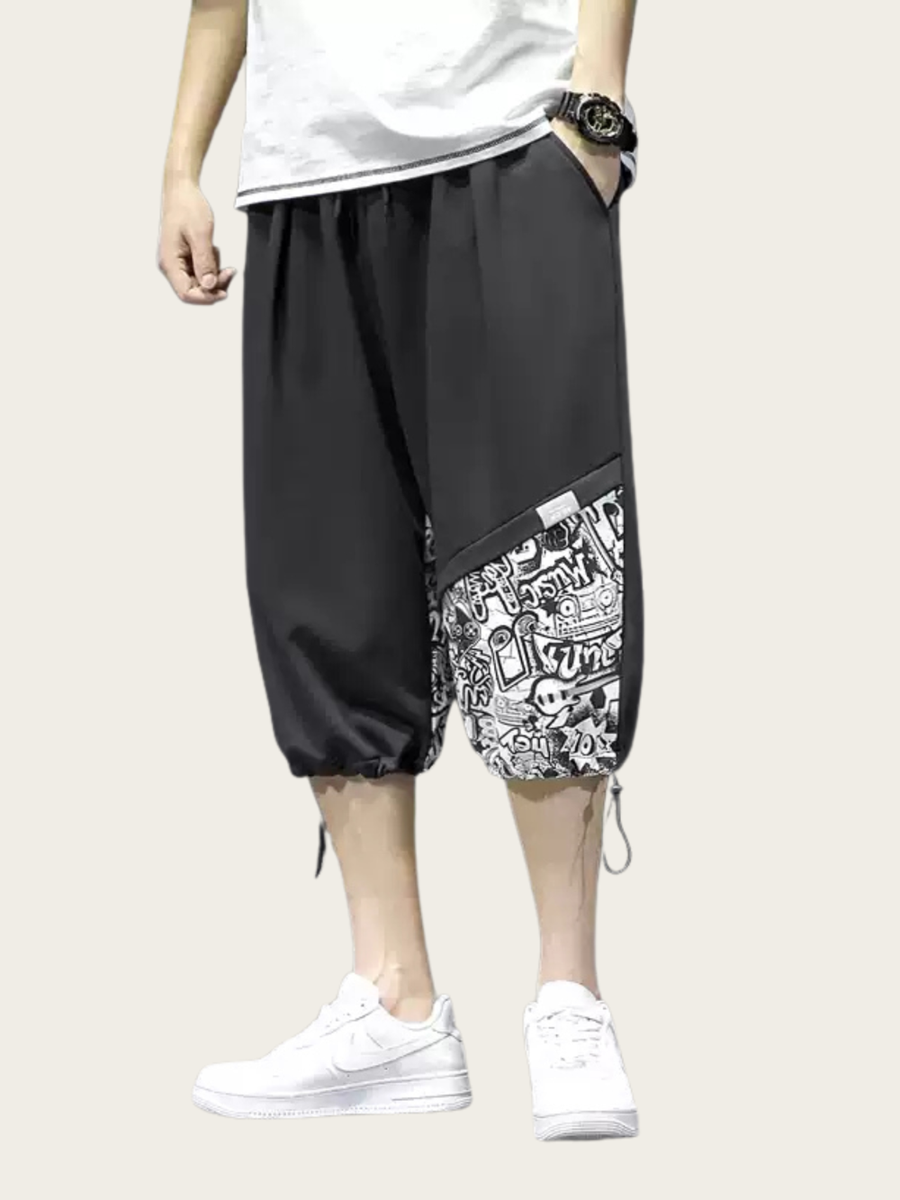 Person wearing black shorts with a patterned pocket on a white background