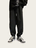 Person wearing black pants with a small blue logo on a white background