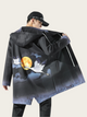 Person wearing a black coat with artistic design on the back, standing against a plain background