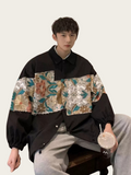 Person wearing a black and floral jacket holding a drink against a white background