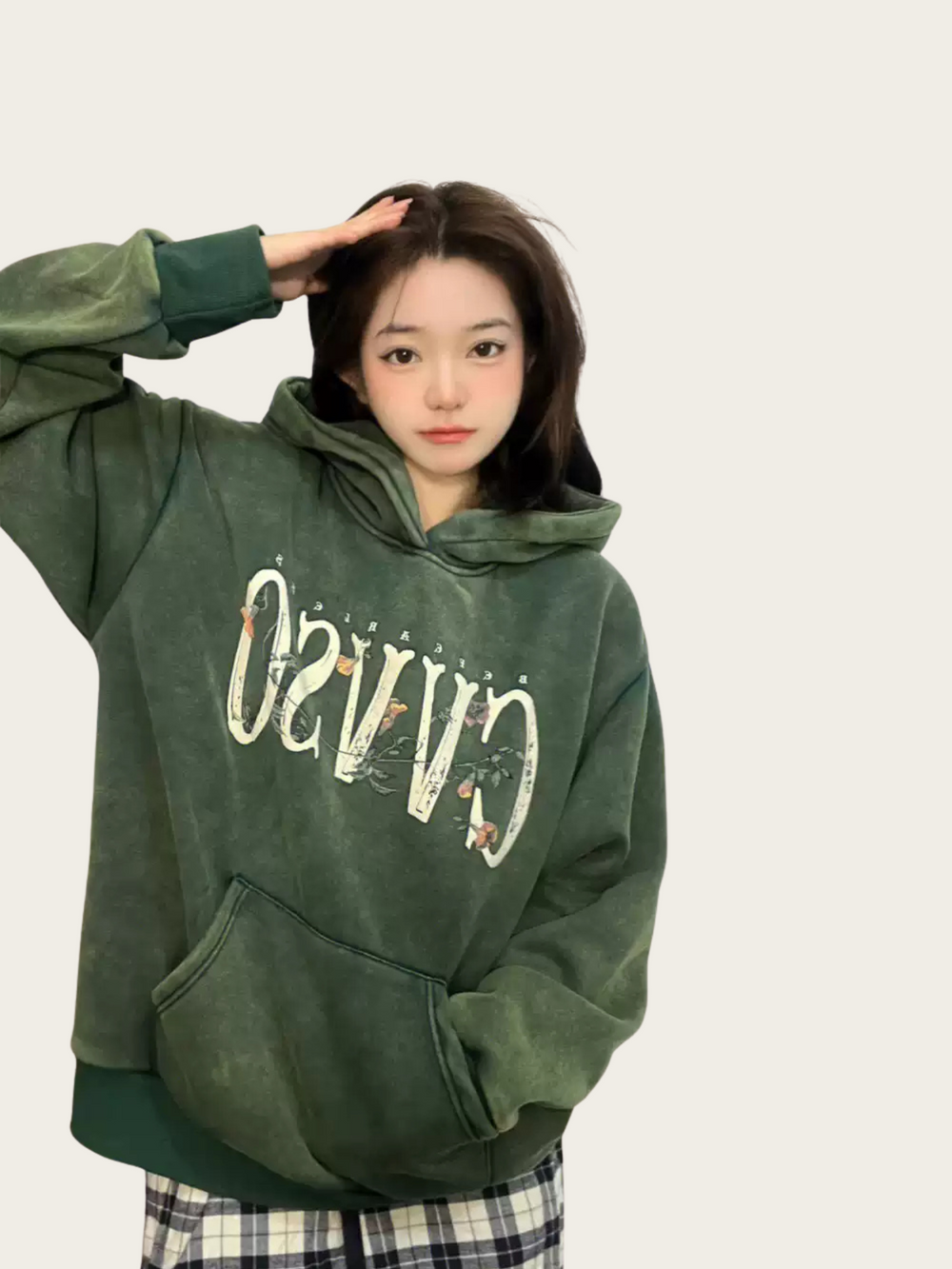 Person wearing a green hoodie with text on a plain background