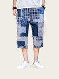 Person wearing blue and white checkered shorts on a white background