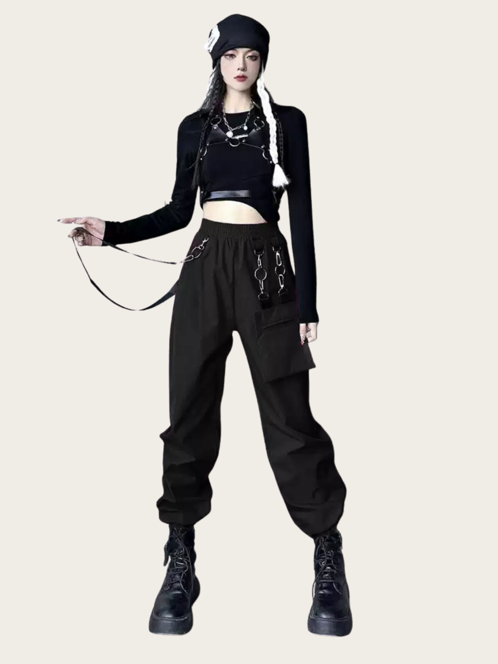 Person wearing a black outfit with suspenders on a white background
