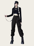 Person wearing a black outfit with suspenders on a white background