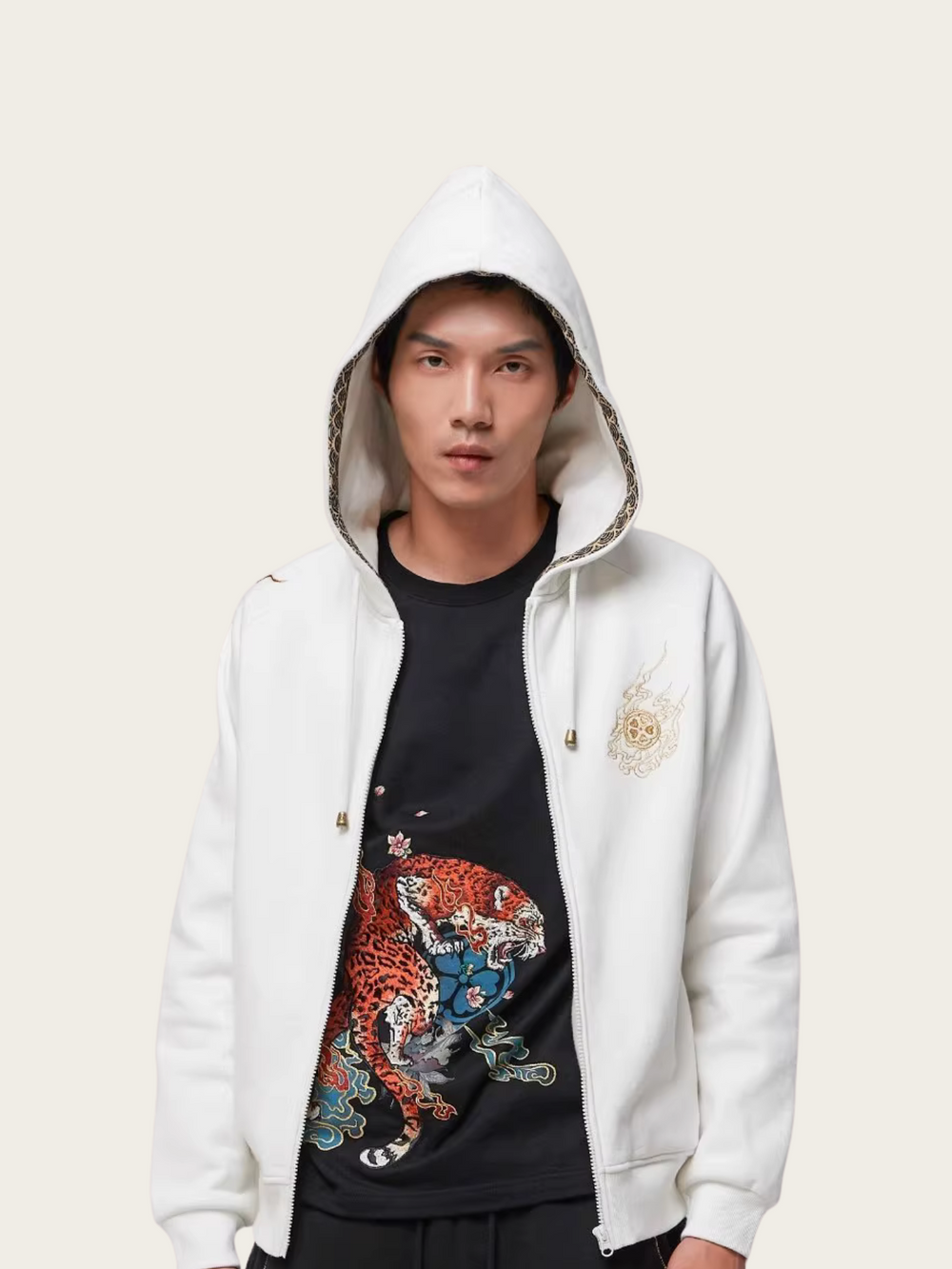 Person wearing a white hoodie with a colorful design on a plain background