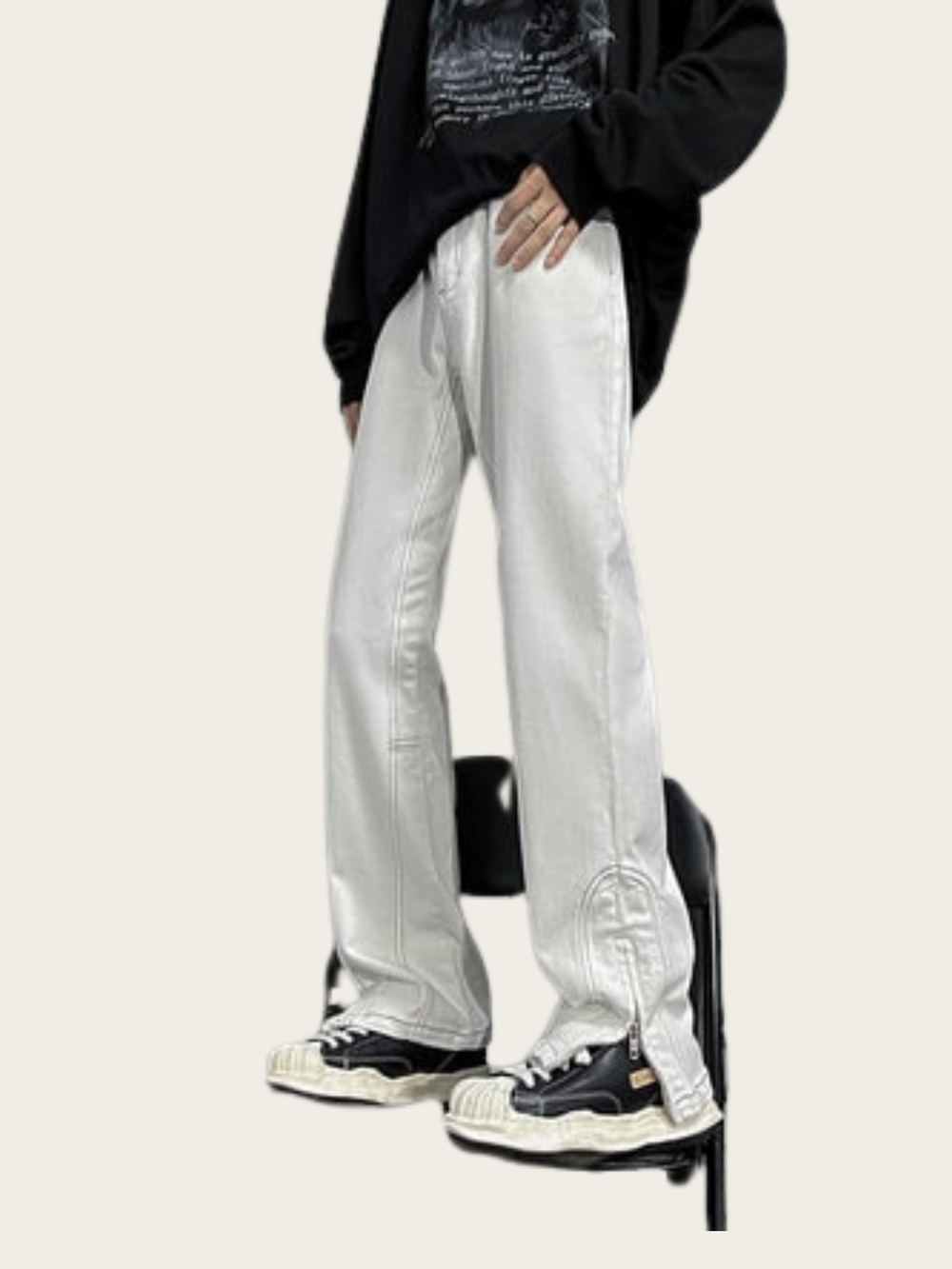 Person wearing silver pants and black sneakers on a white background