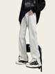 Person wearing silver pants and black sneakers on a white background
