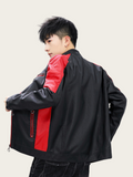 Person wearing a black and red jacket on a plain background