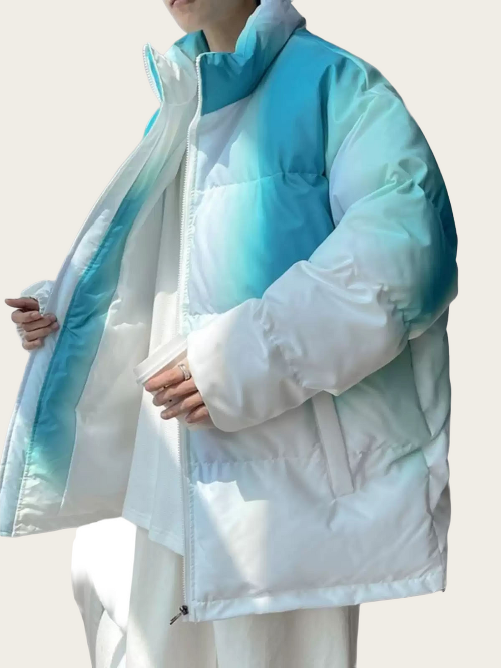 Light blue and white puffer jacket worn by a person on a light gray background