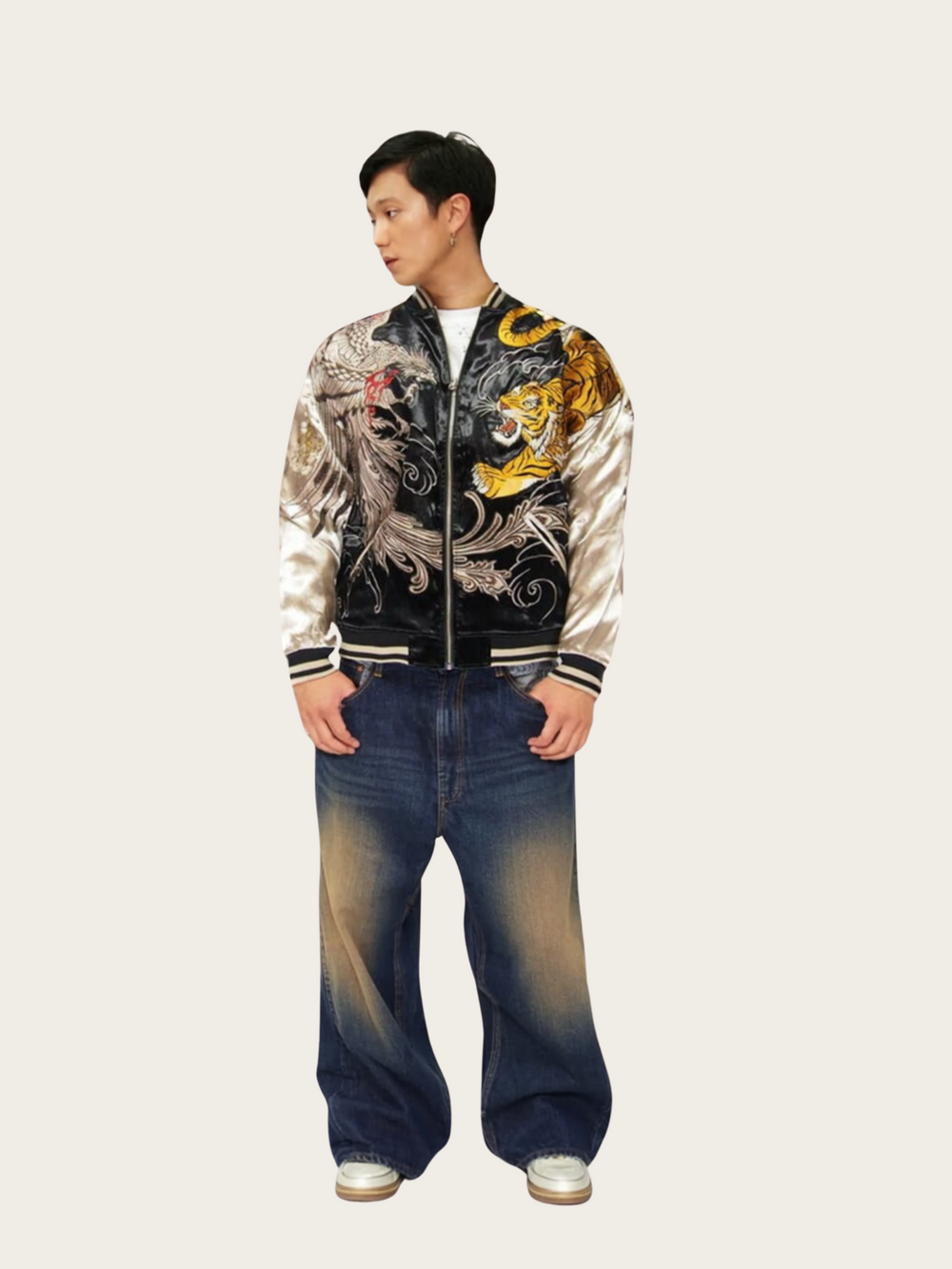 Person wearing a stylish jacket with dragon design and blue jeans on a white background