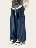 Person wearing blue denim overalls on a plain background