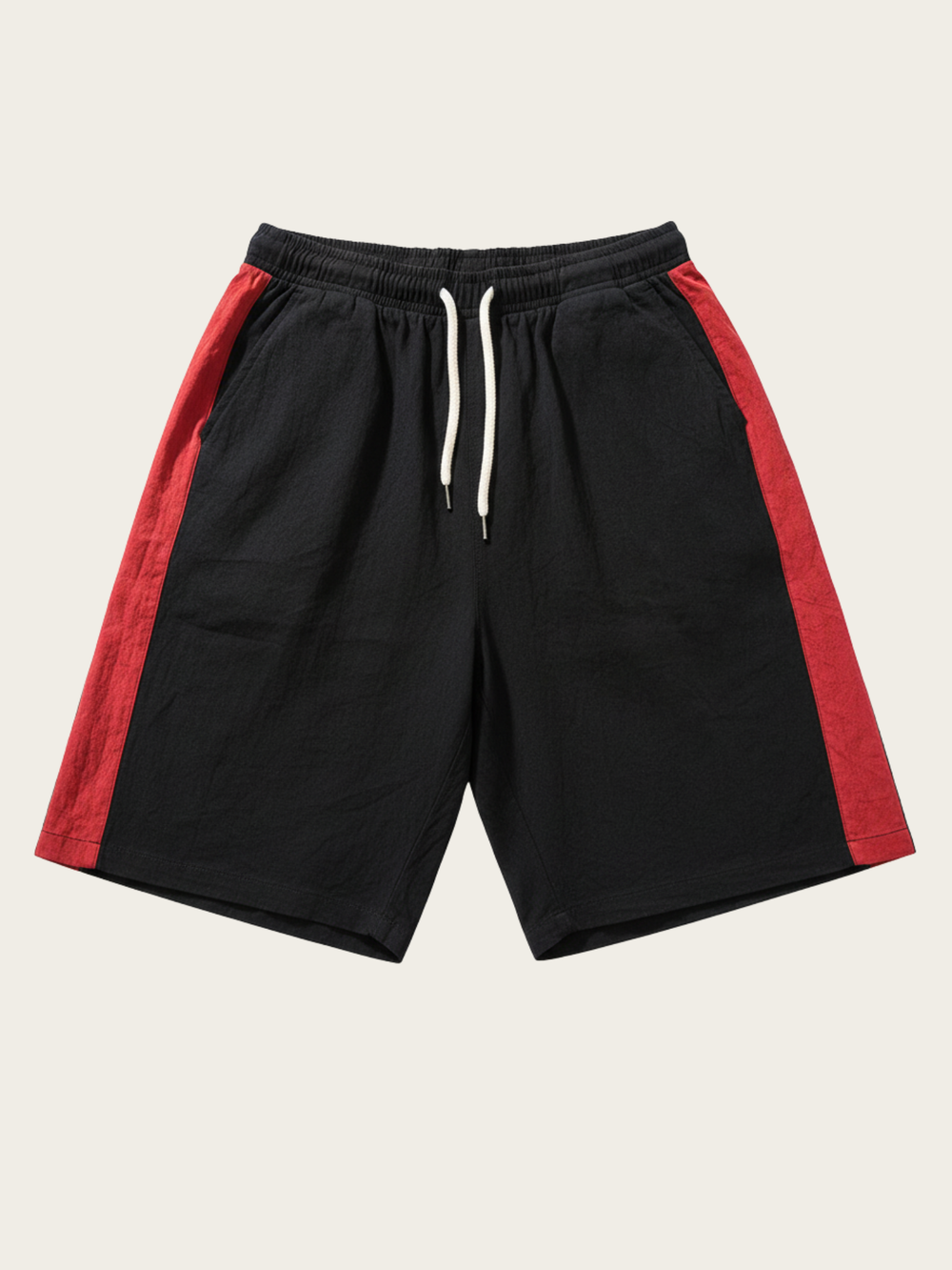 Black shorts with red side panels on a beige background