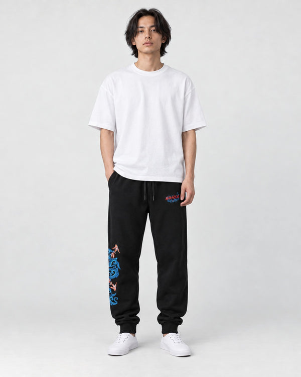 Model wearing the Men's Black Sweatpants with Embroidered Koi and Waves, front view