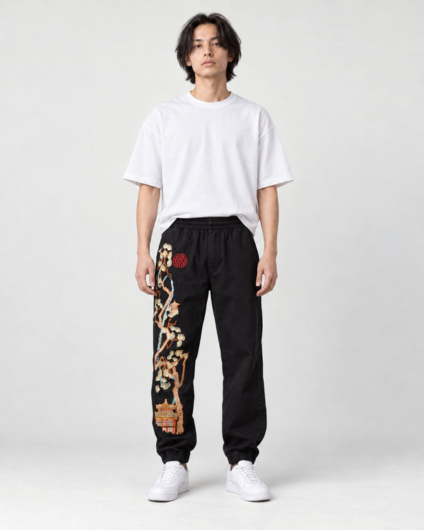 Model wearing the Embroidered Joggers with Pine Tree and Pavilion Design, front view