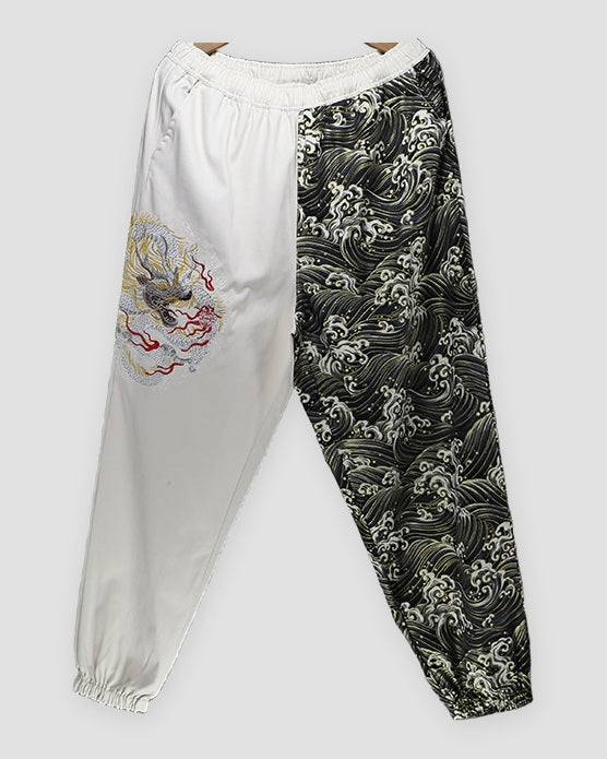 Cream and wave-print jogger pants with an embroidered dragon on the cream leg, front view
