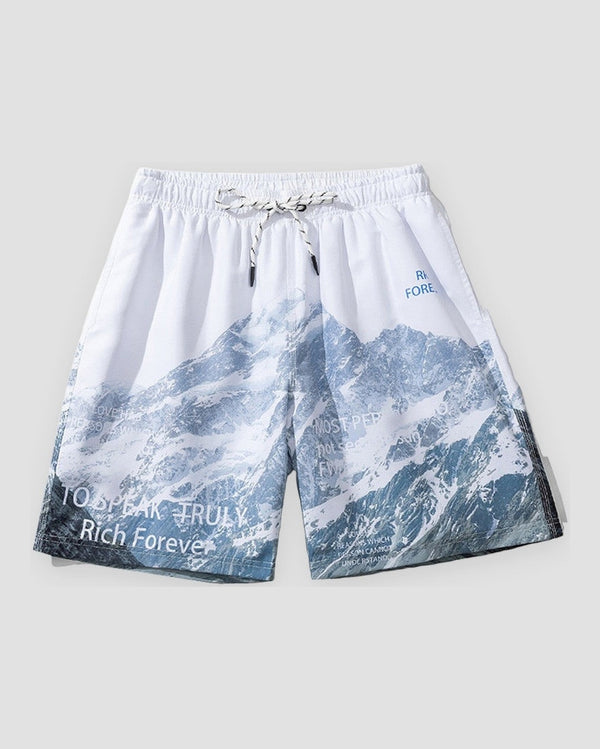 White drawstring shorts printed with blue snowy mountains, with Rich Forever lettering at the lower front