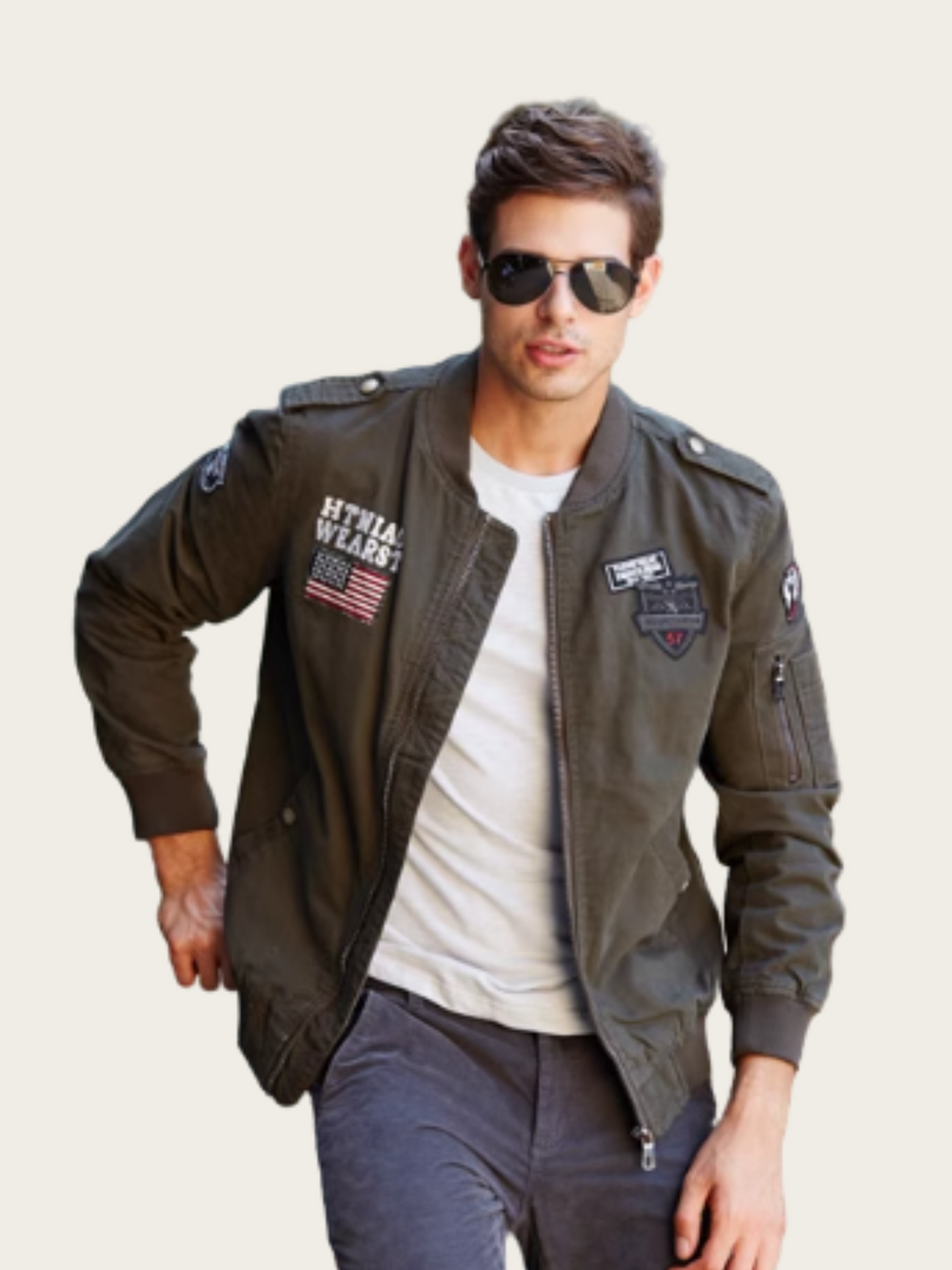 Man wearing a green bomber jacket with patches on a beige background