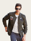 Man wearing a green bomber jacket with patches on a beige background