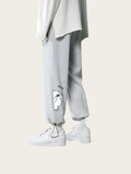 Light gray sweatpants with a small white graphic on a white background