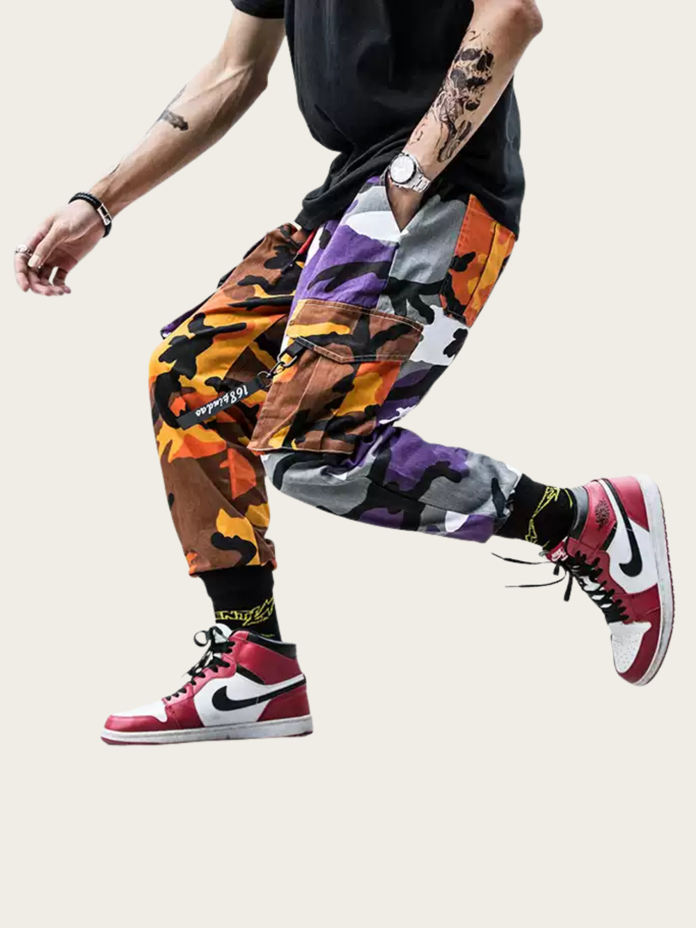 Person wearing colorful camouflage pants and red Nike sneakers on a light background