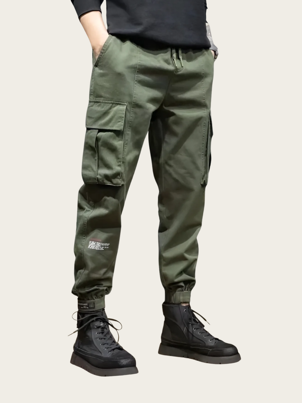 Person wearing green cargo pants and black boots on a light background