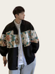 Person wearing a black jacket with floral embroidery on a plain background