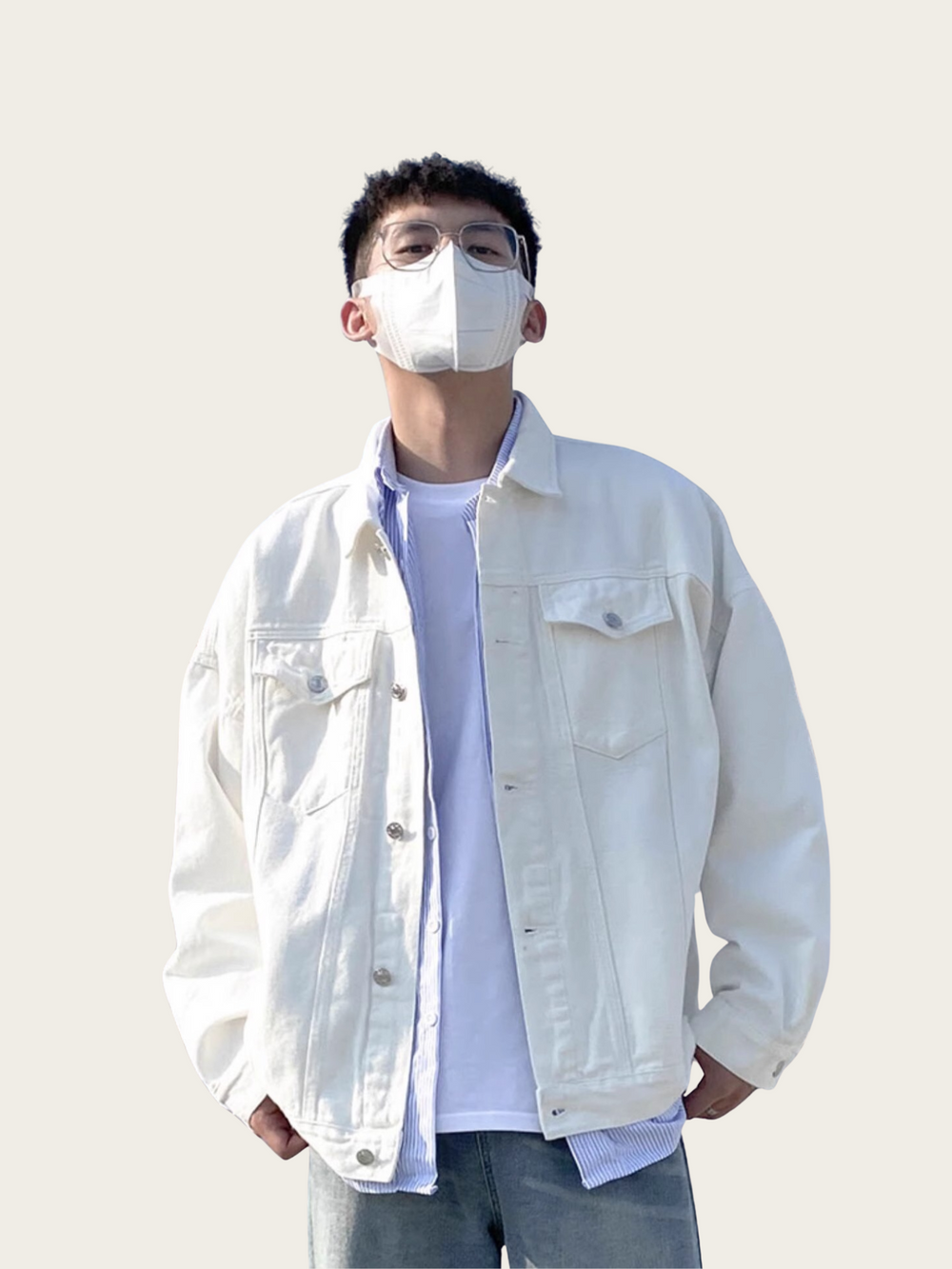 Person wearing a white denim jacket and face mask against a plain background