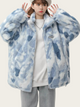 Person wearing a blue and white patterned coat on a plain background