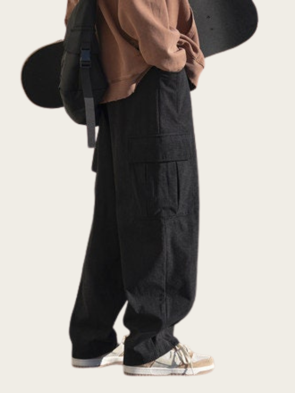Person wearing black cargo pants with a neutral background