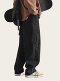 Person wearing black cargo pants with a neutral background