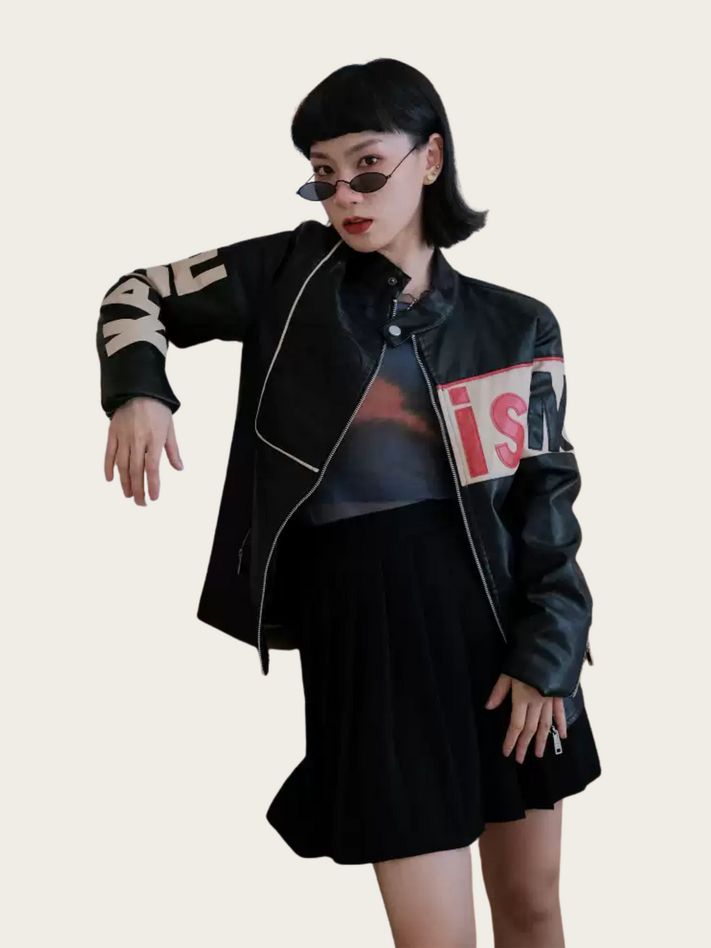 Person wearing a black jacket with text on sleeves against a plain background