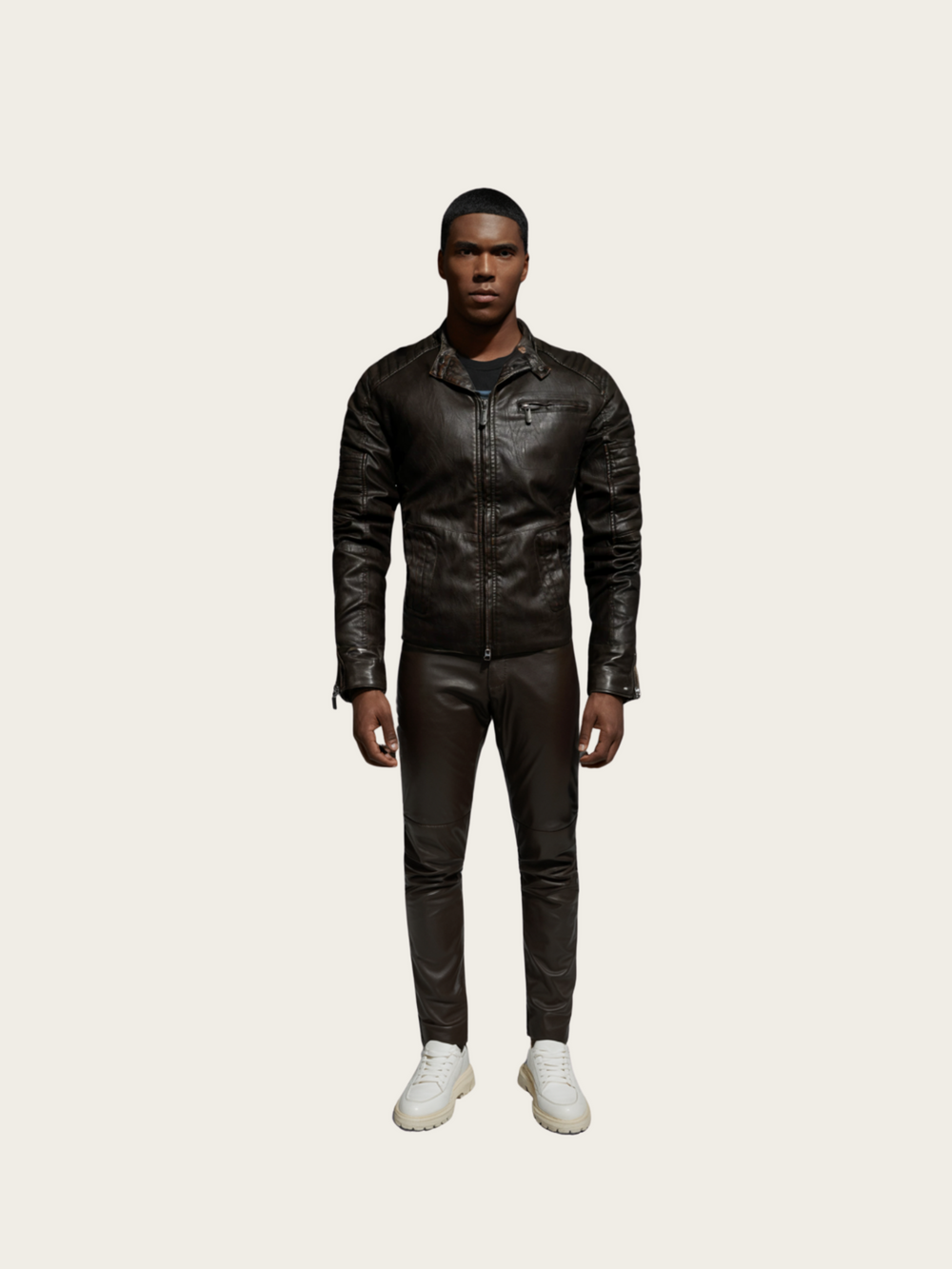 Person wearing a black leather jacket and pants on a light gray background