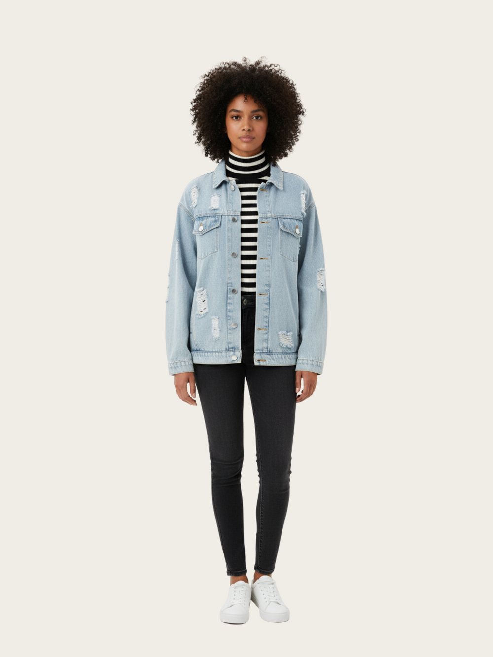 Person wearing a light blue denim jacket over a striped shirt on a white background