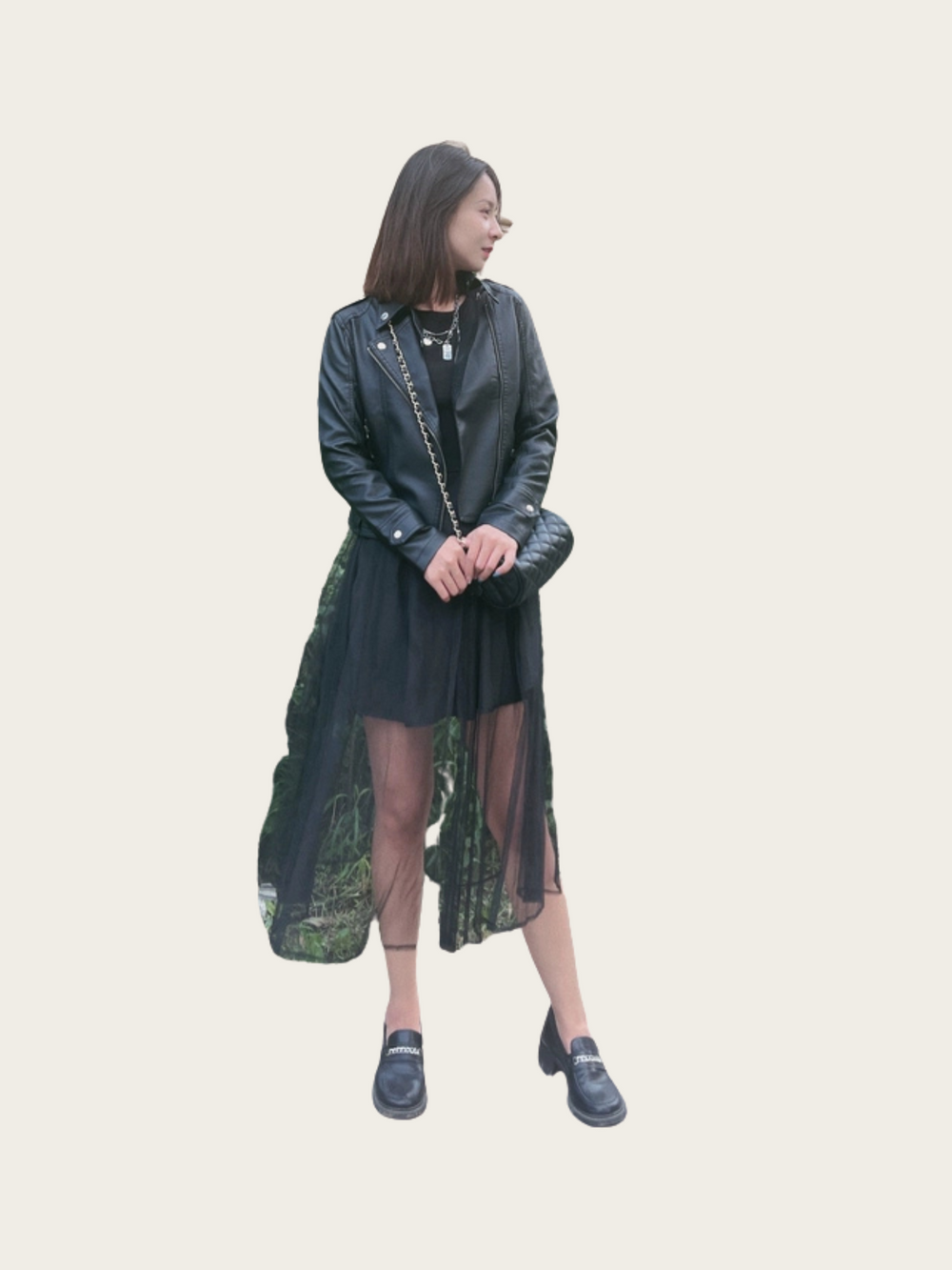 Woman wearing a long dark green dress with sheer overlay on a light background