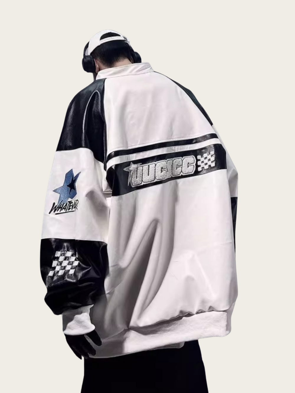 Person wearing a white and black jacket with logos on the back against a light gray background