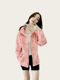 Woman wearing a pink jacket taking a selfie on a white background