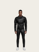 Man wearing a black leather jacket and pants on a beige background