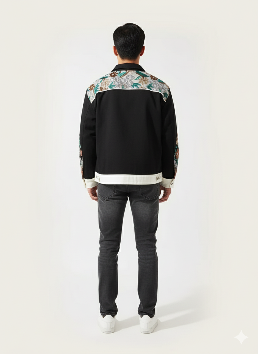 Person wearing a black jacket with floral patterns on a white background