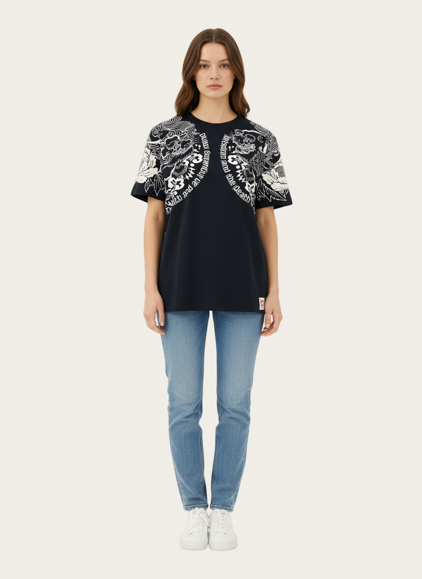 Woman wearing a black t-shirt with white patterns and light blue jeans on a white background