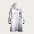 White garment with dragon designs on a stone wall background