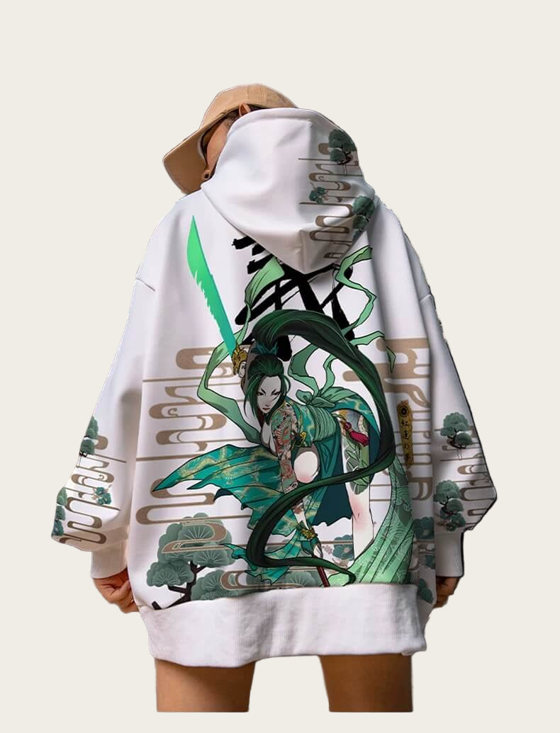 Person wearing a white hoodie with green and black graphic design in an industrial setting